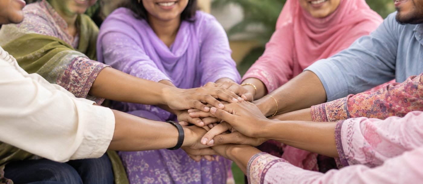 Community members joining hands together in support of Shapla Wellbeing's work